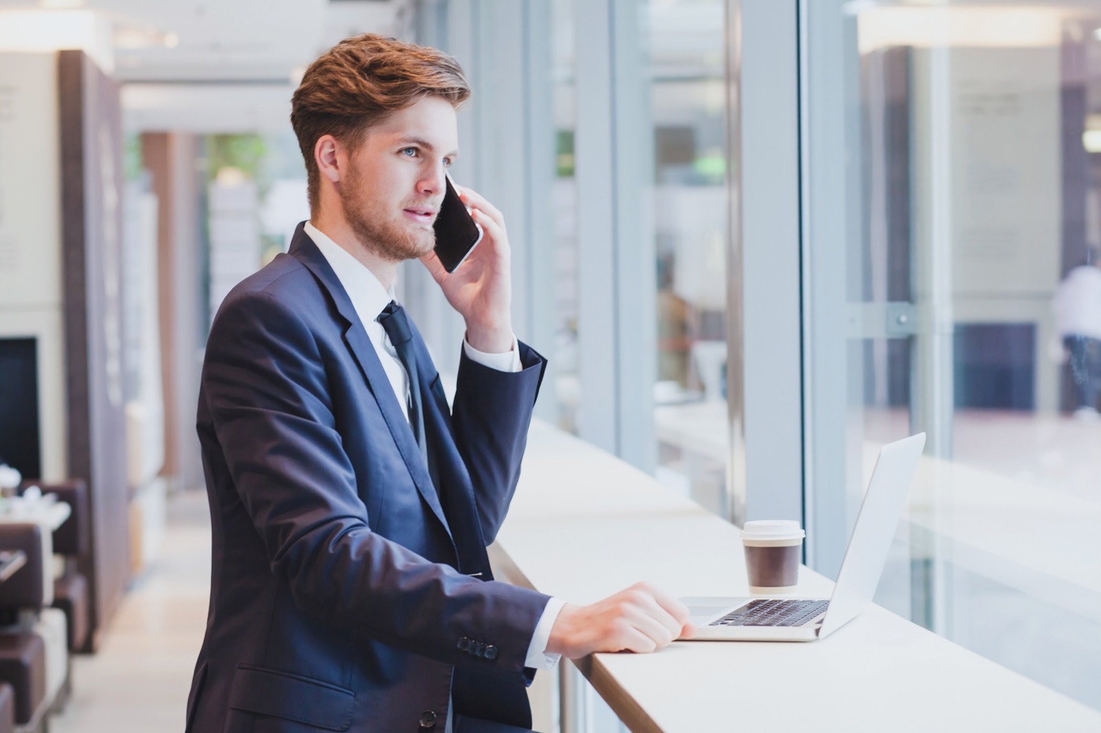 Businessman on the phone at a laptop in an office